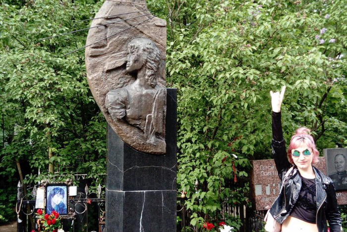 Поклонники несут цветы на могилу Цоя в Петербурге в годовщину его смерти